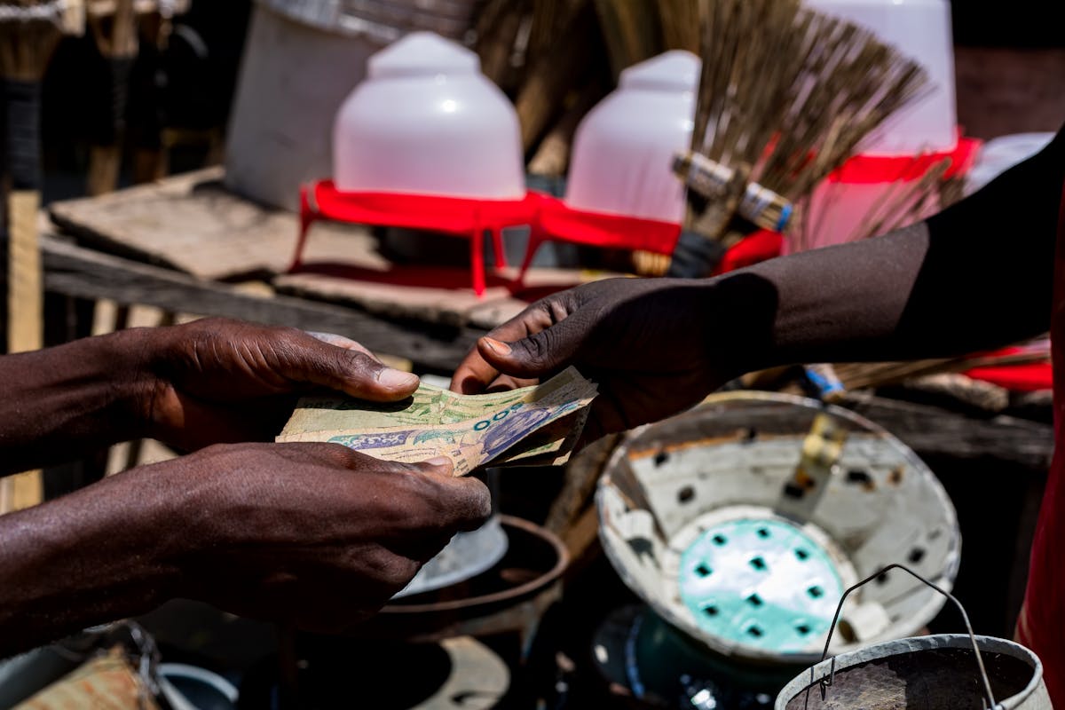 Hands exchanging banknotes across a market stall
