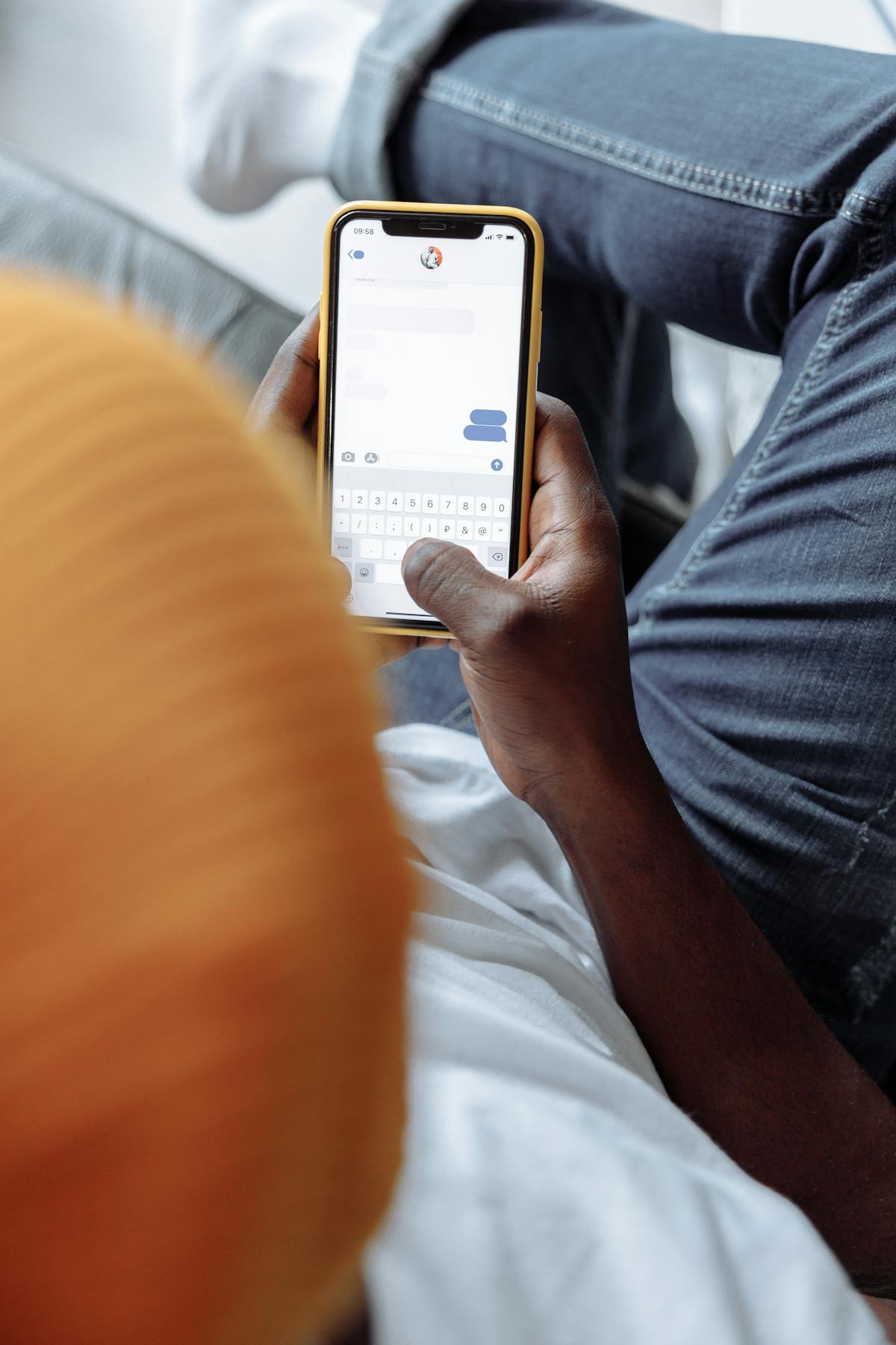 Hands holding a phone showing a messaging conversation